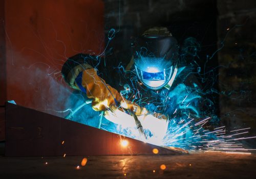 A metal worker is seen on a job. SMF does metal fabrication for agriculture.