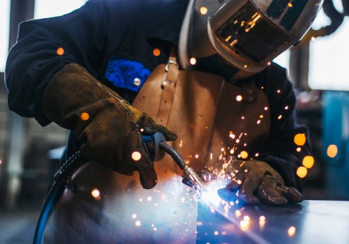 Un hombre realizando soldaduras, parte de la fabricación de metales en Illinois