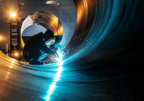 A man cutting and welding large metal pieces, part of Metal Fabrication for Rockford IL