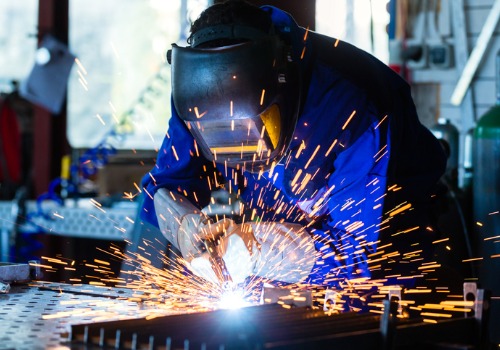 Un hombre soldando metal durante la fabricación de metal para Chicago IL