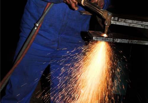 An operator is seen using a plasma cutter to cut through metal. SMF offers Plasma Cutting in Springfield IL.
