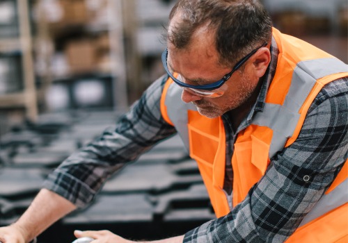 A man is seen working on an assembly line. SMF offers Mechanical Assembly Greenville SC.