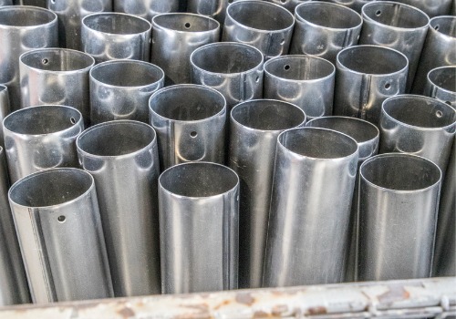 Metal pipes are seen in a factory. SMF performs Steel Fabrication in Rockford IL.