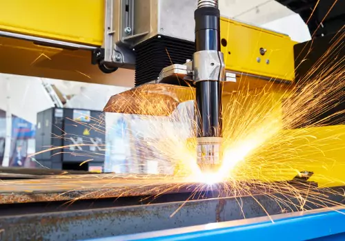 A laser cutter is seen in operation. SMF offers custom metal fabrication. 