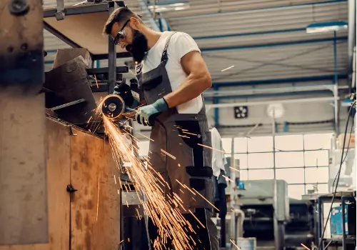 Se ve a un trabajador en un taller metalúrgico. ¿Cuáles son los fundamentos de la fabricación de metal? SMF realiza fabricación de metales.
