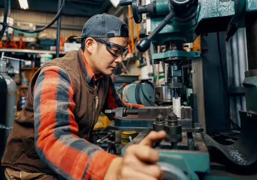 ¿Qué es el mecanizado? Se ve a un trabajador del metal realizando un mecanizado en una fábrica. SMF es un taller integral del metal.