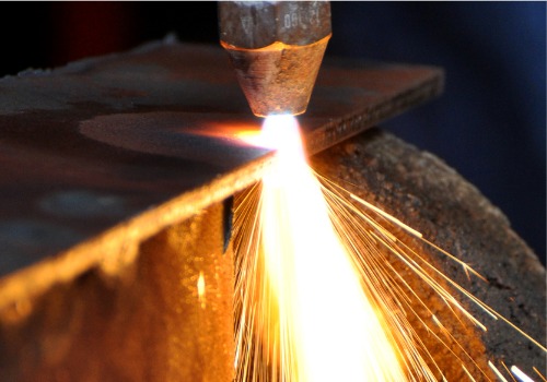 Sparks are seen flying from a plasma cutter. SMF offers metal cutting.