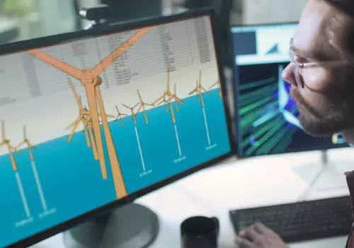 A worker looks at plans for a wind turbine. SMF performs metal fabrication for renewable energy.